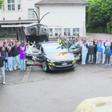 Zum Schmetterling werden - Das gehört dazu: Solarpionier Louis Palmer macht ein Gruppenbild der Niederwiler Schülerinnen und Schüler mit seinem SolarButterfly. Bilder: Chregi Hansen / zg