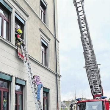 Flugzeug knallt in Schulhaus - Gesichert mit Seil werden die Schulkinder via Feuerwehrleiter evakuiert.