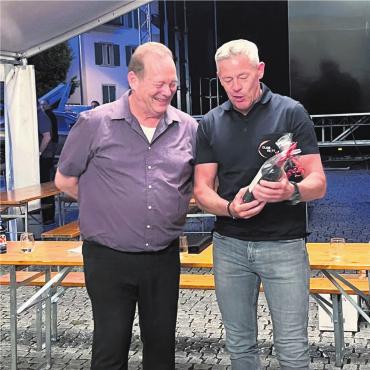 Nach der Flöte getanzt - Skip Healy (links) brachte die Handball-Community zum Staunen. «Club 66/11»-Präsident Christoph Koch bedankt sich mit einer Flasche Wein. Bild: zg