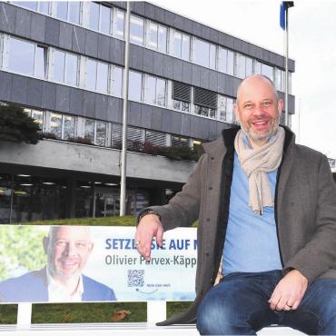 «Ich bin voller Tatendrang» - Die Vertretung der linken Seite: Olivier Parvex auf seinem Wahlkampfbänkli vor dem Gemeindehaus. Bild: Daniel Marti