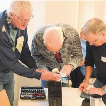 Sich gegenseitig helfen - Gleich zu dritt kümmerte sich das Team um die defekte Kaffeemaschine. Dabei wird viel gefachsimpelt. Bilder: Chregi Hansen