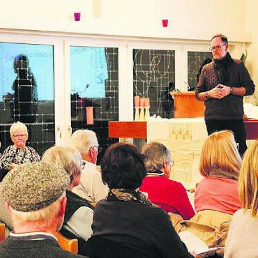 Immobilien im Vordergrund - Präsident Michael Stalder führt durch die gut besuchte Kirchgemeindeversammlung in der Kirche Villmergen.