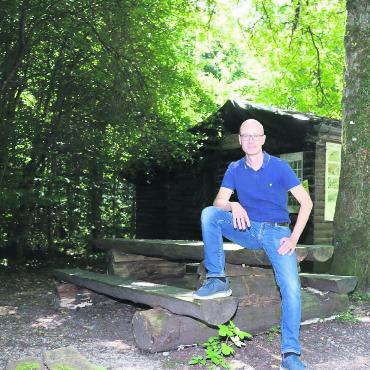 Bewilligung in Aussicht - Vizeammann Yves Moser vor der alten und baufälligen Waldhütte. Hier soll die neue Waldhütte entstehen. Bild: rb