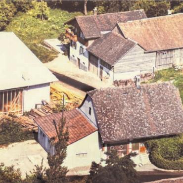 Eigenen Wurzeln treu geblieben - Einst und heute: Links eine Luftansicht aus dem Jahr 1965 mit dem Saxehus (vorne), dem Elternhaus (hinten) und einem Teil der Holzbauhalle. Das Bild rechts zeigt eine Drohnenaufnahme des gesamten Betriebsgeländes von 2025.