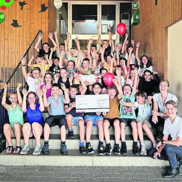 Der Jubel ist gross - Doppelter Jubel – Gewinn des Klassenpreises über 500 Franken, der kurz vor dem Start der Sommerferien durch Nadja Bissegger und Levin Keusch von der Raiffeisenbank Reuss-Lindenberg übergeben wurde. Bild: zg