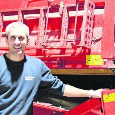 Für mehr Toleranz - Kartoffelproduzent Raphael Müller vor seiner zweiten Leidenschaft: die Maschinen wie der Vollernter. Bild: Monica Rast
