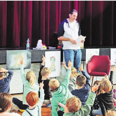 Bilder in Worte verwandeln - Startschuss für die Kleinsten: Autor Stefan Sprenger liest den 40 Kindern (und 50 Begleitpersonen) aus seinem Kinderbuch Chnorrlimorrli vor. Bild: Adrian Humbel