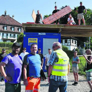 Besuch bei «Frönde» rückt näher - Das OK und die Helfer sind voll motiviert. Trotz Sonne und warmen Temperaturen sind sie auch für einen kurzen Fotostopp bereit. Vorne in der Mitte präsentiert OK-Präsident Ruedi Seiler das Gilet mit passendem Fest-Aufdruck. Bilder: Verena Anna Wigger