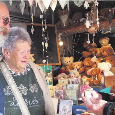 Das Marktleben ist schön - Florierender Osterhandel: Voller Freude zeigt Marktfahrer Paul Vogel (rechts) dem interessierten Paar eine gegossene Figur aus seinem Sortiment. Bild: Bernadette Oswald