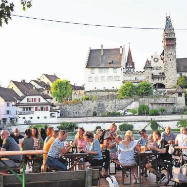 Reussufer lädt zum gediegenen Fest - Die Bremgarter Städtli-Kulisse hinter den rauschenden Wogen sorgt auf der eigens für das Reussfoodfestival angefertigten Flussterrasse jeweils für unvergleichliche Genussmomentein Bremgarten. Ab morgen Mittwoch ist es wieder so weit. Bild: Marco Huwyler (Archiv)