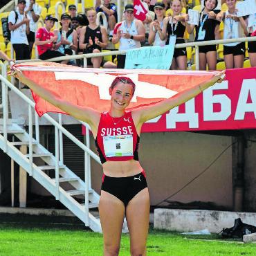 Hug feiert ihren grössten Erfolg - Mit Lachen und Schweizer Fahne: Norina Hug holt sich die Silbermedaille und lässt sich im Stadion feiern. Bild: Swiss Olympic