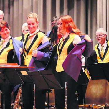 Neue Gilets für die «Musig» - Als Überraschung wurde mitten im Konzert das neue goldgelbe Gilet dem Publikum präsentiert. Bild: rb