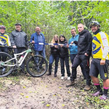 Im Einklang mit der Natur - Das Band zur Eröffnung des Mountainbiking-Trails wurde von den beteiligten Akteuren gemeinsam durchgeschnitten. Bild: mub