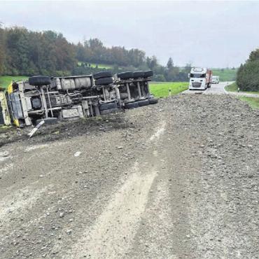 Lastwagen umgekippt - Kies und Geröll auf der Strasse, der Muldenkipper umgekippt daneben. Bild: pz
