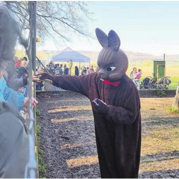 Eiersuchende aus nah und fern - Der Osterhase hat für die vielen Kinder, welche gerne noch ein Ei hätten, eines dabei. Die Hand durch den Zaun gehört zum alljährlichen Ritual.