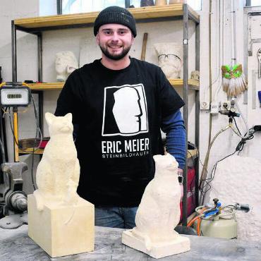 Werke für die Ewigkeit - Der Künstler mit einem seiner ersten Werke: Die Katze hat er im Rahmen seiner Ausbildung gemacht. Zuvor hat ein Modell aus Gips hergestellt. Für Eric Meier ist die Steinbildhauerei viel mehr als bloss ein Handwerk. Bild: Chregi Hansen