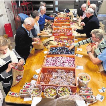 Viele Säckli für ein Dach - Die Mitglieder und der Anhang des Kiwanis Club Lindenberg füllen in der Backstube der Bäckerei Kreyenbühl in Muri die 2000 Chlaussäckli ab. Bild: zg