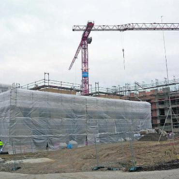 Neues Quartier entsteht - Drei hohe rote Kräne dominieren aktuell das Bild der Baustelle im Widacher – und damit das gesamte Dorfbild von Fischbach-Göslikon. Bild: Roger Wetli