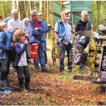 Holz als Wertstoff bewusst machen - Eine andere Generation: Der Werkzeugarm des Vollernters wird bestaunt.