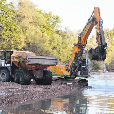 Der Weg der Flusssteine - Auf einer aufgeschütteten Kiesbank mitten in der Reuss arbeiten aktuell ein Bagger und ein Lastwagen. Bilder: Celeste Blanc