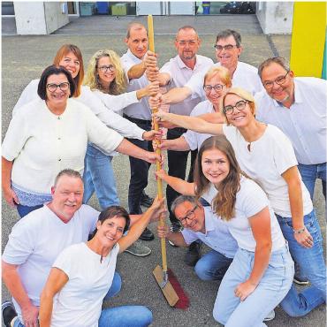Das Dorf und das Miteinander feiern - Mottotreu greift das OK zum Besen. Am Stiel von unten: André Käppeli, Urs Schneebeli, Steffi Sprenger, Lisa Heggli, Präsidentin Claudia Dober, Vreni Sidler, Rebi Schwitter, André Konrad, Simone Meier, Kari Suter, Nici Steiner, Beni Niederer und Roger Klausner.