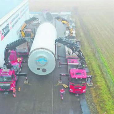 Riesentrommel geht auf Reisen - Gewusst wie: Die grosse, 48 Tonnen schwere Trommel wird von vier LKW-Kränen angehoben. Danach kann der Anhänger rückwärts unter die Trommel gefahren werden.