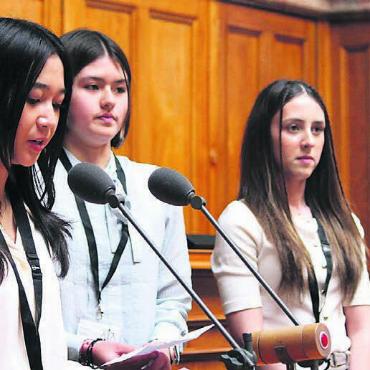 Von der Schulbank ins Bundeshaus - Morin, Aurora Müller und Chayenne (v. l.) halten ihre Rede im Nationalratssaal im Bundeshaus in Bern. Bild: zg