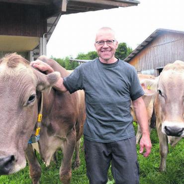 Mit der nötigen Geduld - Hanspeter Müller inmitten seiner Milchkuh-Herde. Fanta ist dafür verantwortlich, dass er mit 21 Kühen über 100 000 Kilogramm Milchleistung den nationalen Rekord hält. Bild: Annemarie Keusch