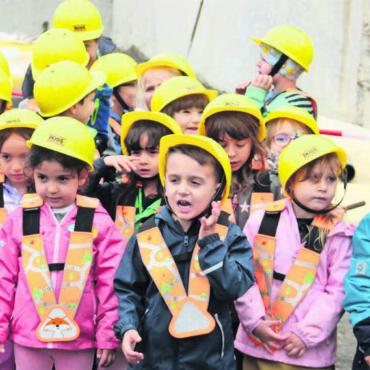 Baustelle gleich vor der Tür - Die Kindergärtler präsentieren bei der Grundsteinlegung ihr eigens dafür komponiertes Lied. Bilder: Monica Rast