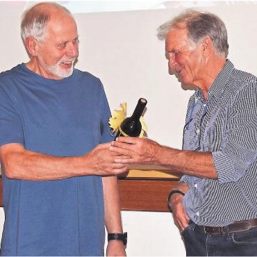 Wind in den Haaren - Hans Kneubühler (links) von der Kulturkommission überreichte dem Referenten Cyrill Heimgartner eine Flasche Wein, einen «Hambeler». Bilder: Erika Obrist / zg
