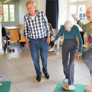 Trainings im Alltag - Die Teilnehmenden übten ihr Gleichgewicht auf abgerundeten Hölzern. Bilder: Roger Wetli