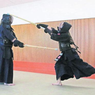 Familiensache Kendo - Erwischt. Yumi Kröbl (rechts) trifft ihren Vater Chris mit dem Bambusschwert am Kopf. Es ist eine der vier Körperstellen, an denen man im Kendo mit einem Treffer punkten kann.