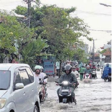 Studium mit Surfbrett - Chaotischer Verkehr und Überschwemmungen: auf Bali beides keine Seltenheit.
