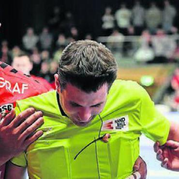 Kuriose Szene - Der portugiesische Nationalspieler João Ferraz (links) und Nicolas Waldvogel vom HSC Suhr/Aarau helfen Daniel Maurer vom Feld. Bild: awa