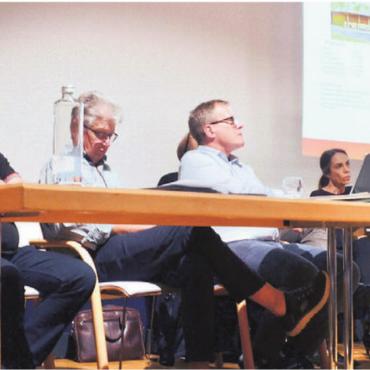 Auf das Notwendige reduziert - Für die Informationsveranstaltung zum Badi-Ausbau hat sich Gemeinderat Beat Küng (rechts) eine geballte Ladung an Expertise aufs Podium des Dachtheaters geholt. Bild: Thomas Stöckli
