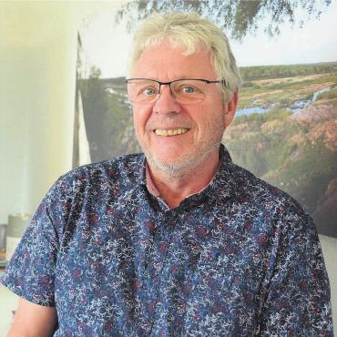 Einsatz für eine gute Schule - Franz Lötscher vor einer Fotografie aus Südafrika, die in seinem Büro hängt. Hierhin zieht es ihn und seine Partnerin regelmässig. «Ich freue mich, mehr Zeit für mich selber zu haben», sagt der 64-Jährige. Bild: Chregi Hansen