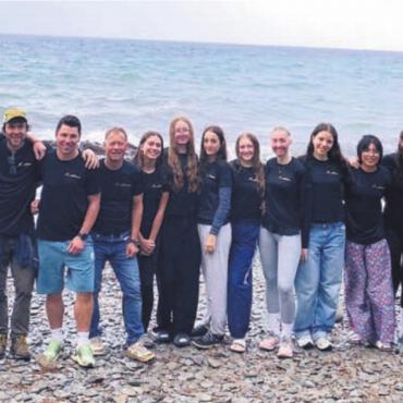 Glücklich und nass am Ziel - Was für ein Timing: Die ganze letzte Etappe durch regnete es, für das Gruppenfoto am Mittelmeer riss der Himmel aber auf. Bild: zg