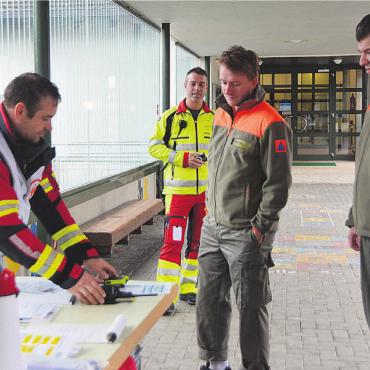 Wenn das Netz total ausfällt - Feuerwehrkommandant David Trottmann (hinten) beobachtet die Übergabe des Notfalltreffpunkts von der Feuerwehr an den Zivilschutz. Bild: Annemarie Keusch