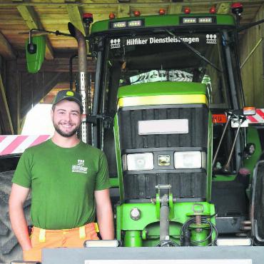Quasi nichts ist unmöglich - Mathias Hilfiker ist der Stolz anzusehen. Dass er sich den Traum des John Deere 7810 und des eigenen Unternehmens erfüllen konnte, macht ihn glücklich. Bild: Annemarie Keusch