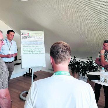 «Schau hin. Es lohnt sich» - Im «World Café» ging es alle zehn Minuten zu einer neuen Fragestellung. Wie hier bei Moderator Pascal von Tobel (links neben Flipchart), der die Voten aufnahm. Ein intensiver Austausch und aufmerksames Zuhören fanden dennoch statt. Bild: Verena Anna Wigger