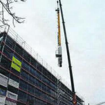 Ein Novum in der Region - Die 23 Meter hohe Stahlsäule wird vorsichtig in die neue Lagerhalle gehievt ...