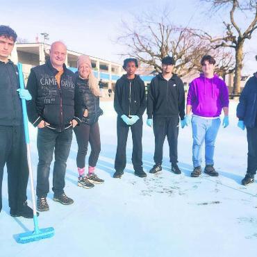 Schuften für die Badisaison - Die 15-Jährigen (blaue Handschuhe) von Klassenlehrerin Petronella Bamert (3. v. l.) helfen dem Team von Badileiter Roger Marti (2. v. l.) unter anderem beim Schrubben der Badebecken. Bild: Marco Huwyler