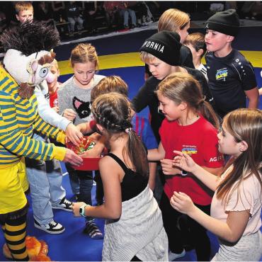 Spende, die aus den Socken haut - Chnorrlimorrli und die Kinder in der Halbzeit des NLA-Halbfinals. Fotos: Alexander Wagner