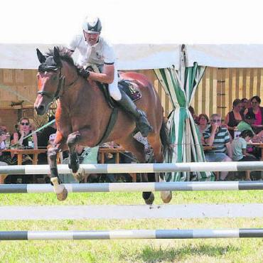 Zwischen Tanz und Teamwettkampf - Im Vordergrund wird geritten, im Festzelt dahinter geniessen die Besucher die Atmosphäre. Die Springkonkurrenz Wohlen ist Wettkampf und Dorffest in Kombination. Bild: Archiv