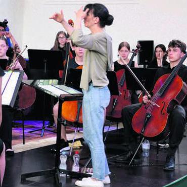 Feinfühlig mit dem Taktstock - Anne-Cécile Gross leitet die jungen Musikerinnen und Musiker mit viel Gespür.