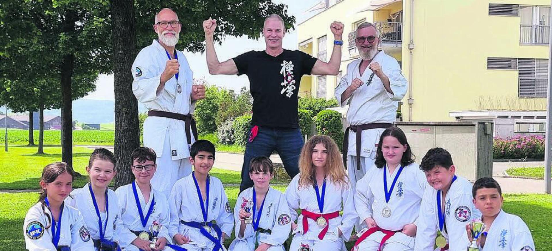 Freude über starke Wohler Karatekas am Seishin-Cup in Seuzach (v. l): Nila Ismajli, Maya Banceanu, Nico Stampfli, Robin Tas, Nils Hoffmann, Weronika Jablonska, Silas Arnold, Noar Hajdaraj, Bernardo Costa Monteiro; stehend: Erich-Andreas Bürgisser, Coach Shihan Raphael Gauch, Roland Konrad. Bild: zg