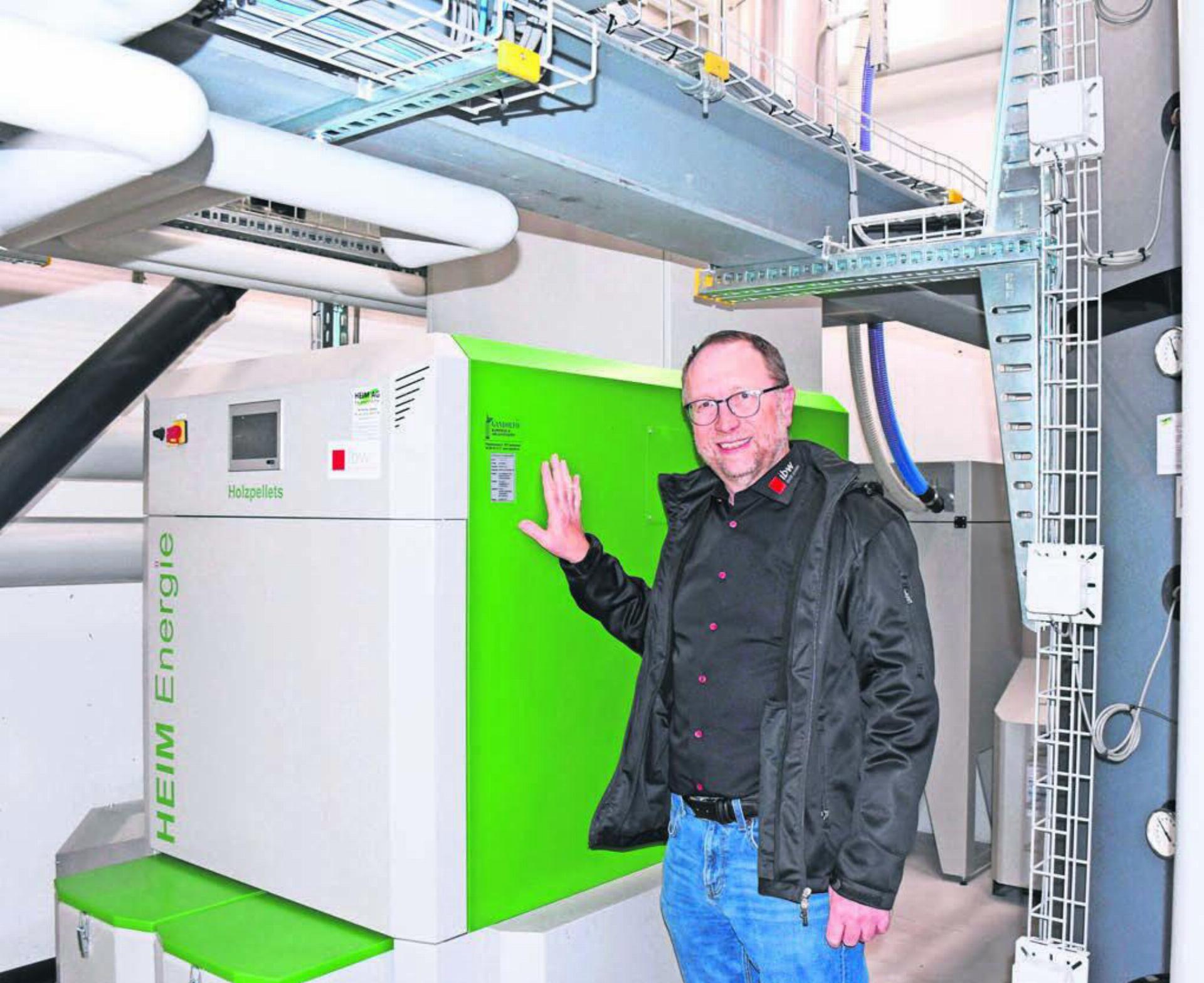Beat Koch, Betriebsleiter Energievertrieb der ibw, zeigt die neue Pelletheizung, ein Pilotprojekt im «Wärmeverbund Wohlen-Süd». Bild: Daniel Marti