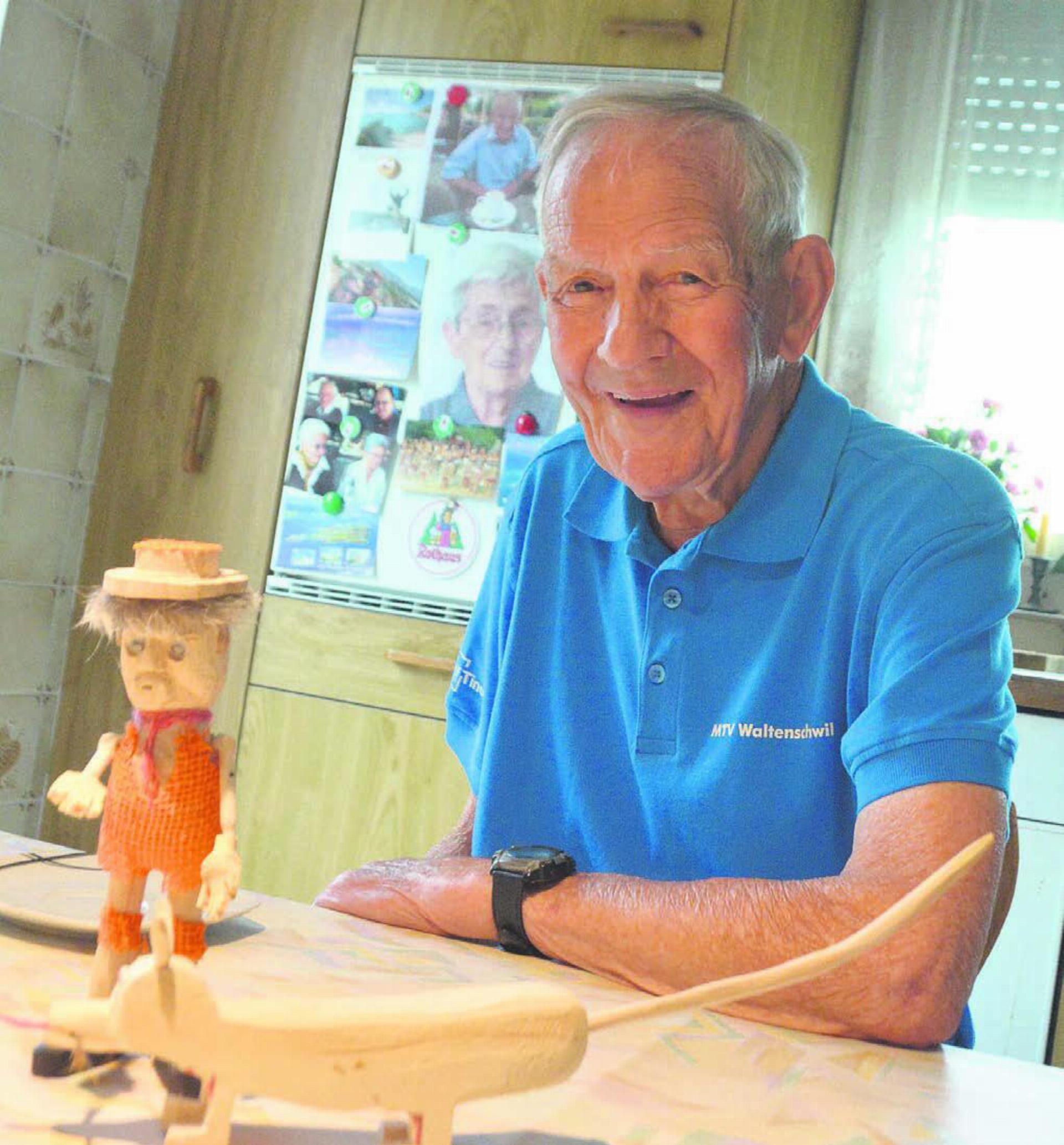 Holzschnitzereien sind auch im hohen Alter immer noch ein grosses Hobby. August Gauch an seinem Küchentisch am Kindergartenweg in Waltenschwil. Bild: Annemarie Keusch