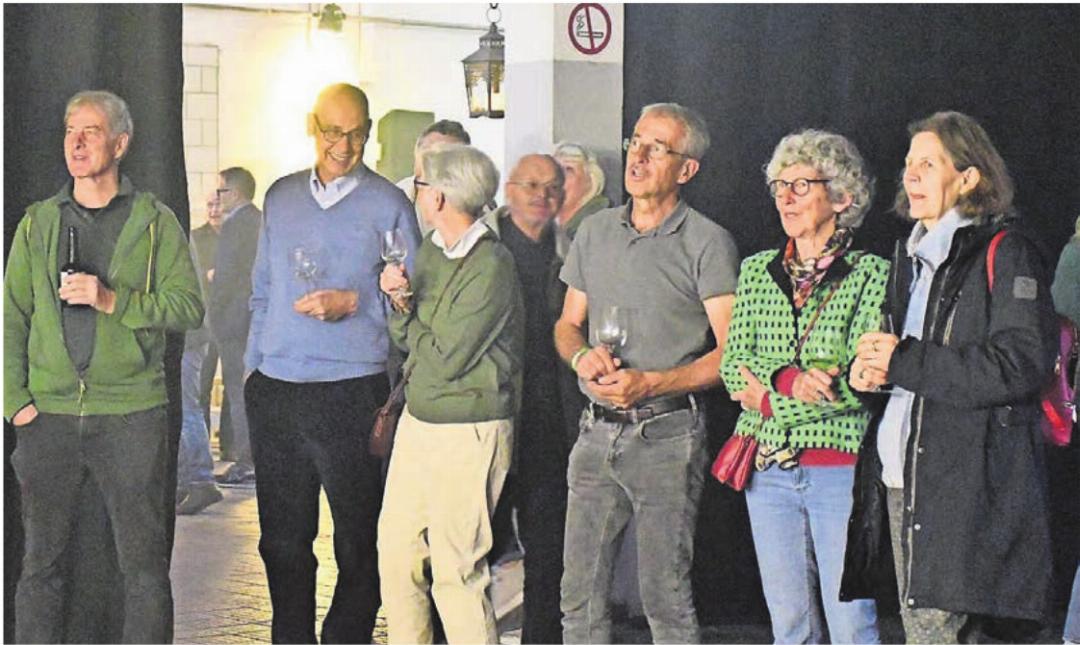 Eine Gruppe von geladenen Gästen begutachten die Anzeigetafel hinter der Bar. Eine Gruppe von geladenen Gästen begutachten die Anzeigetafel hinter der Bar.