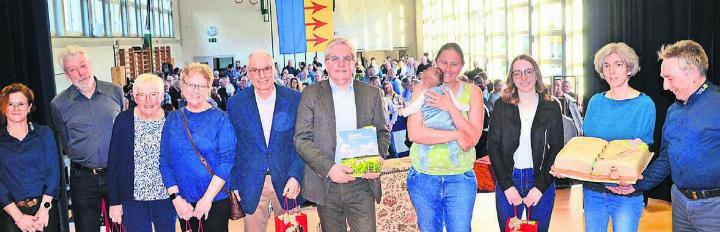 Autor Dieter Kuhn (Bildmitte) mit dem neuen Üezmeler Buch und seiner «Crew». Von links: Gemeindeschreiberin Nicole Jenni mit Pierre Perrenoud, Erika Koch, Jutta Perrenoud und Hans-Peter Eichenberger von der Arbeitsgruppe Ortsgeschichte, Co-Autorin Andrea Lim mit Baby, Grafikerin Ilona Hausherr, Karin Vogel mit Torte in Buchform und Vizeammann Thomas Füglistaler.